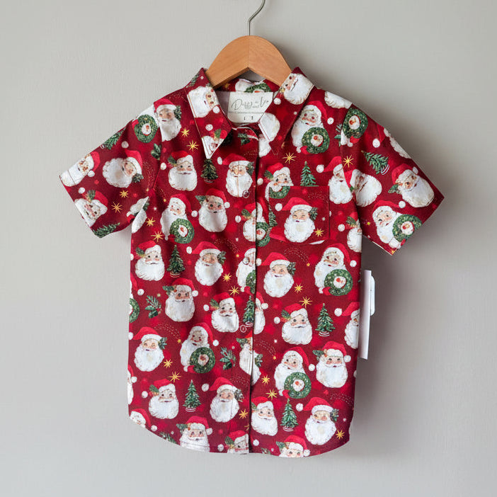 Red shirt with Santa Claus pattern on a hanger against a gray background