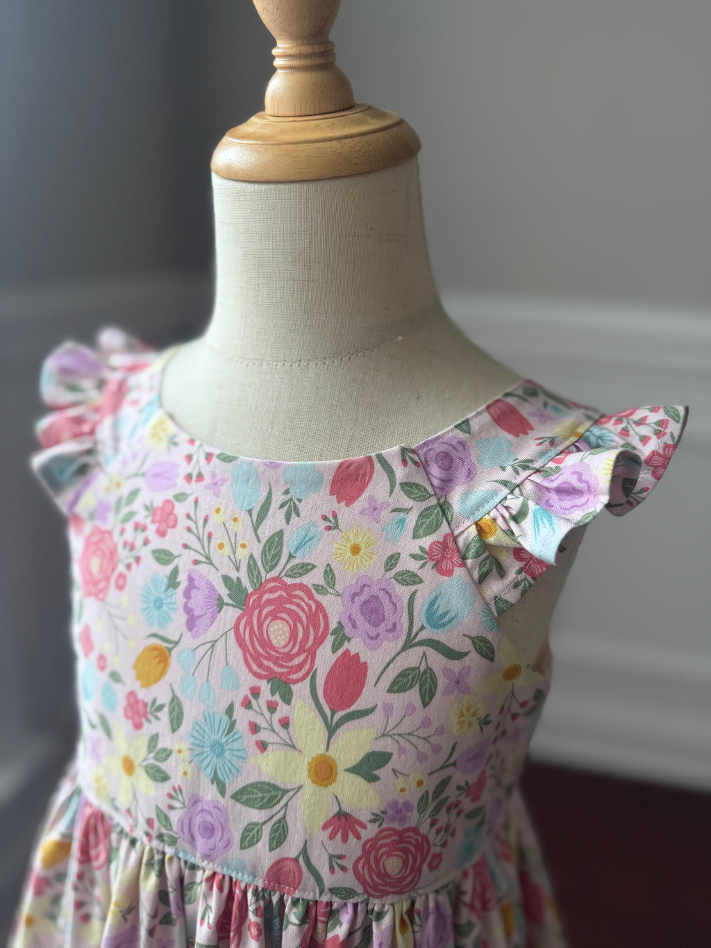 Floral dress on a mannequin against a neutral background